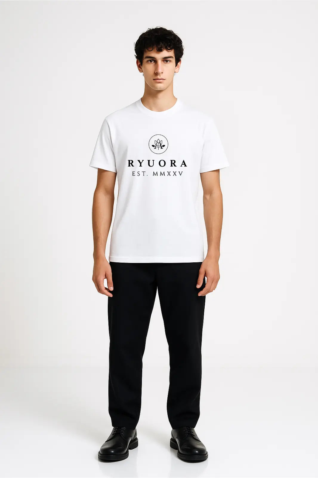 Young man wearing white Ryora branded t-shirt with black pants and black shoes against plain white background