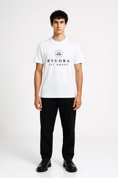 Young man wearing white Ryora branded t-shirt with black pants and black shoes against plain white background