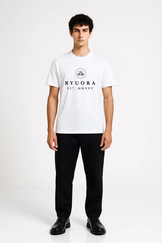 Young man wearing white Ryora branded t-shirt with black pants and black shoes against plain white background