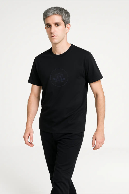 Man with gray hair wearing a black t-shirt with subtle logo and black pants on white background